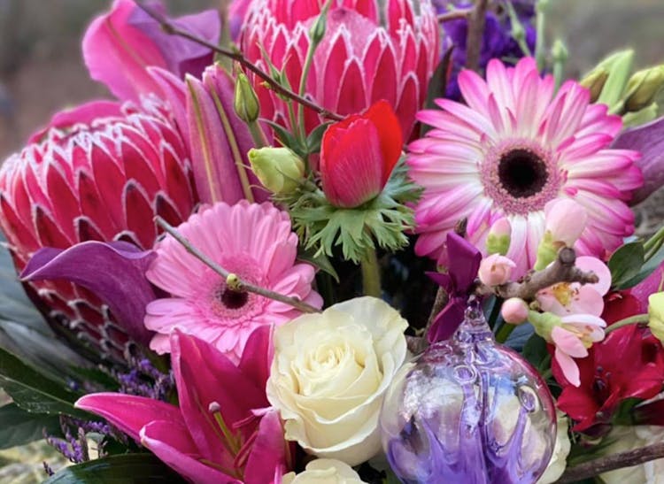 A bright, vibrant floral arrangement, full of pink, red and purple flowers